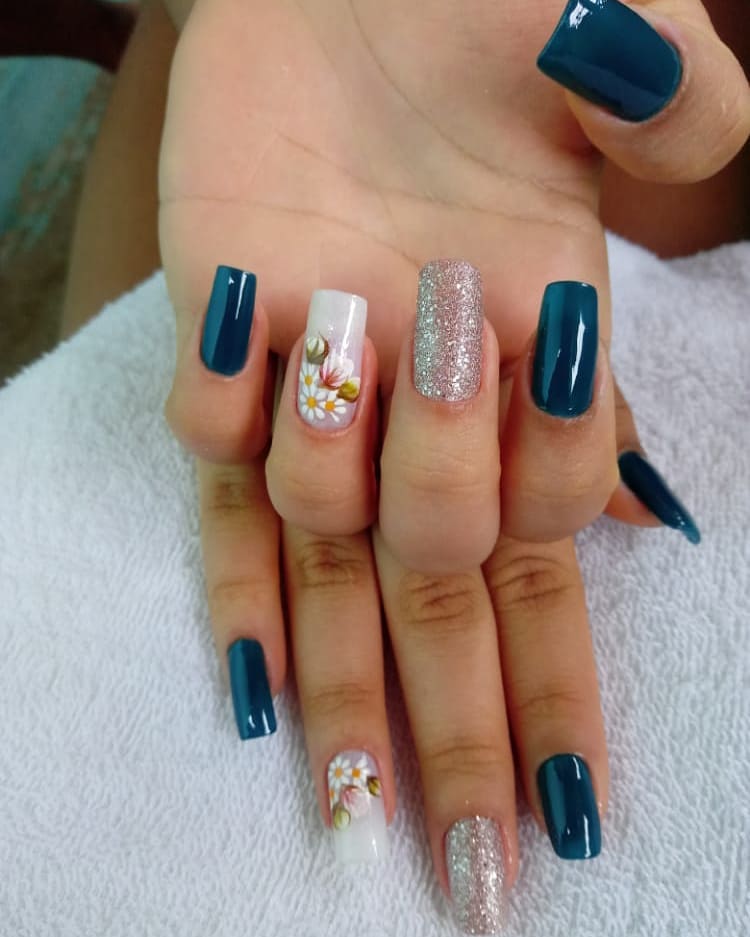 Unhas azuis com detalhes florais e glitter