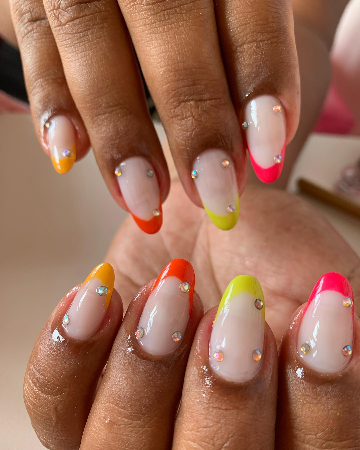 Unhas com francesinha colorida e aplicações de pedras