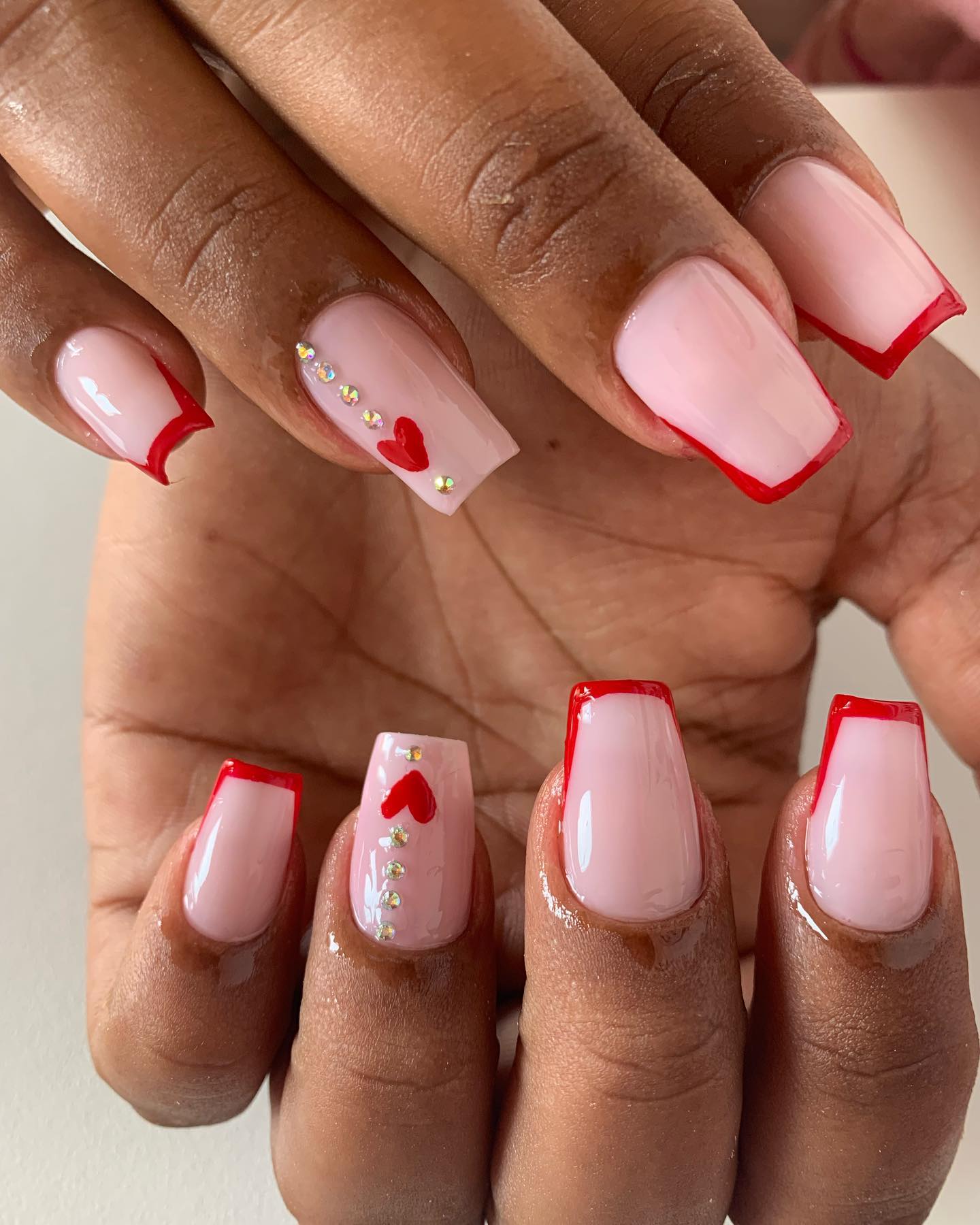 Unhas com francesinha vermelha e detalhes de coração