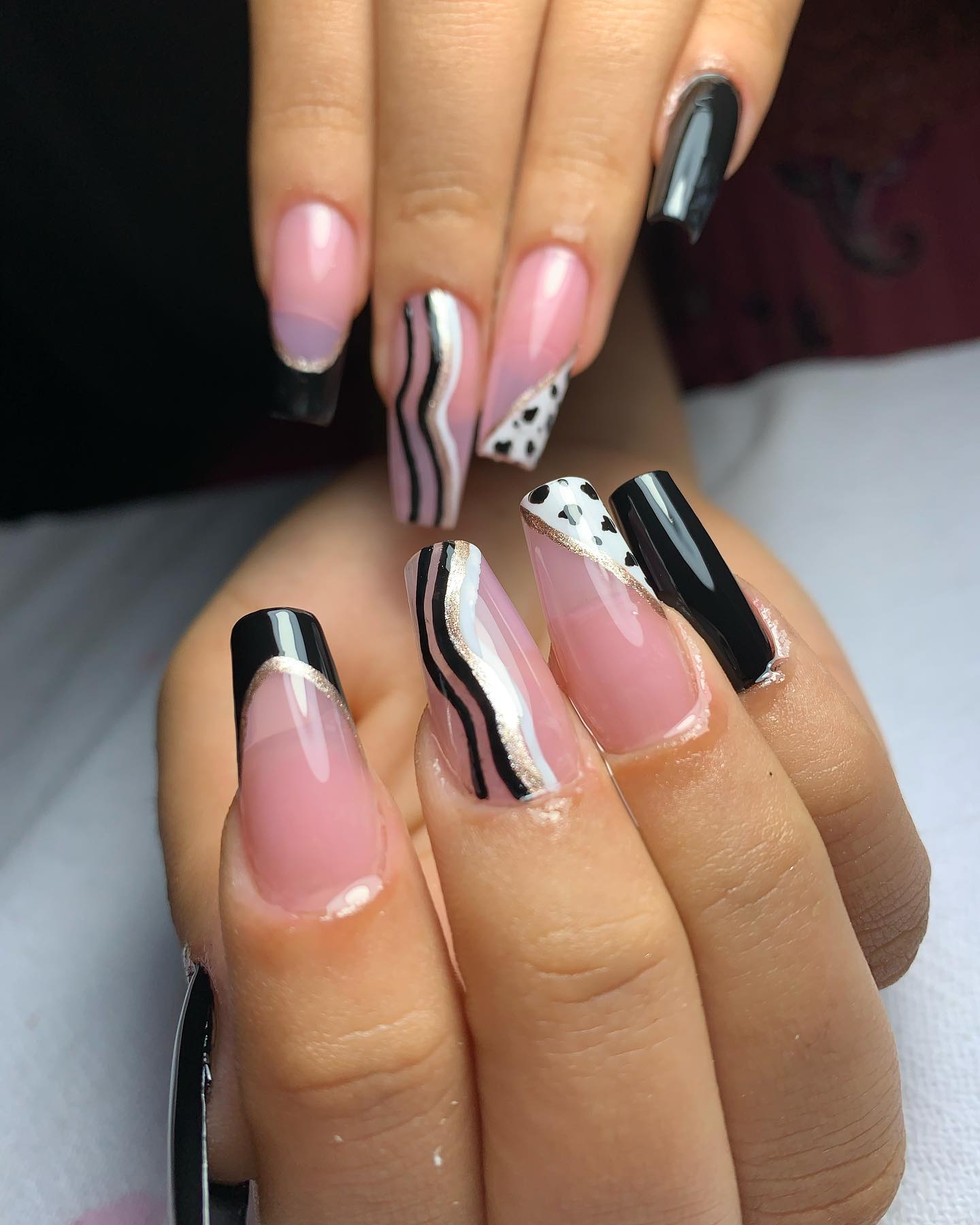 Unhas com design preto e rosa com padrão de dálmata